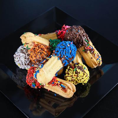 Sandwiched cookies dipped in chocolate and sprinkles.