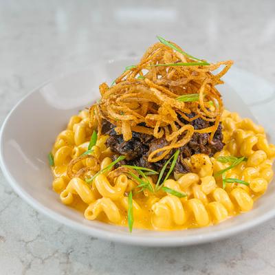 Mac and Cheese, topped with burnt ends, onion straws, and scallions.