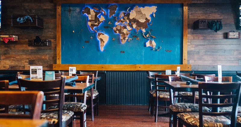 Interior, dining tables and seats, world map on a wall
