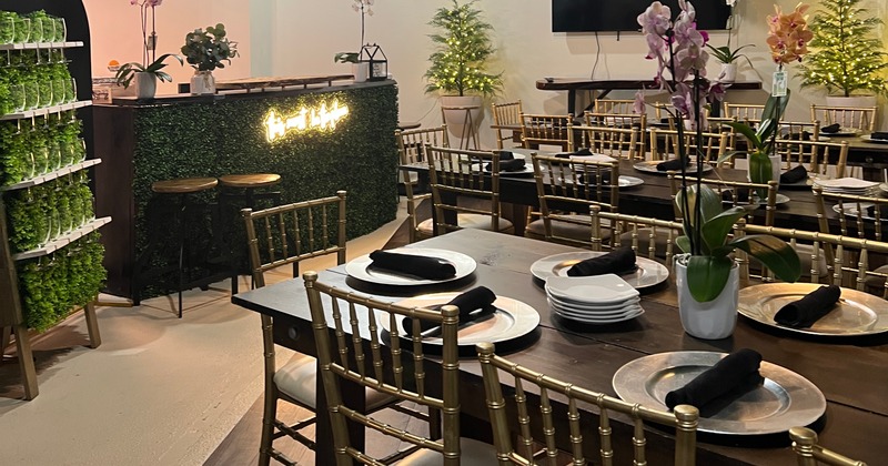 A table with an orange cake, charcuterie board, glasses of mimosa and place settings