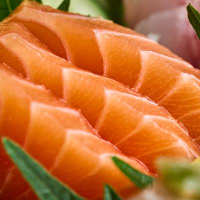 Extreme close up of raw salmon sashimi slices.
