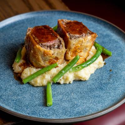 Beef Wellington with mashed potatoes and green beans.