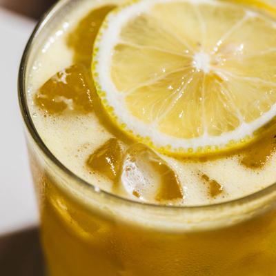 Yellow Sexy UWS Lady cocktail, with a lemon wheel inside the glass, close up.