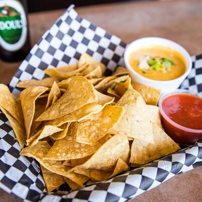 Basket of Chips with housemade queso cheese dip and salsa