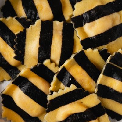 Close-up of black and yellow striped ravioli.