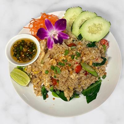 Thai fried rice served with sliced cucumber, lime, and chili fish sauce.