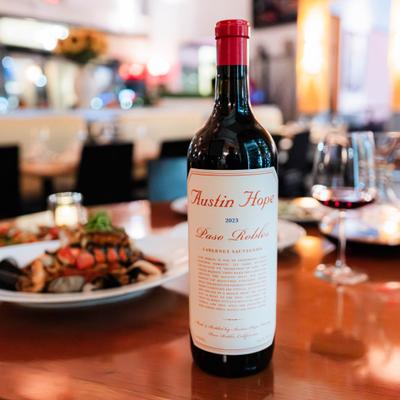 Red wine bottle on a wooden table.