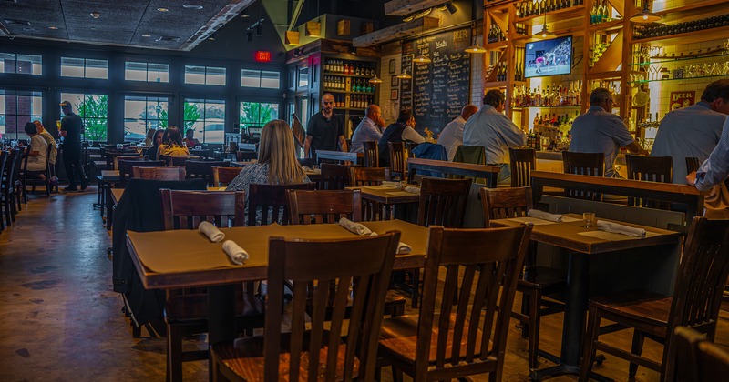 Restaurant interior, dining area and bar area with guests