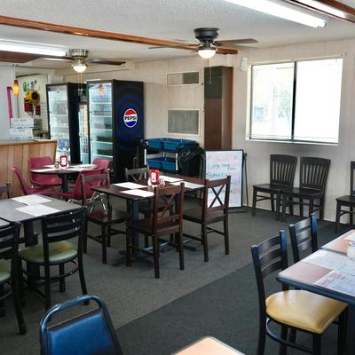 Dining area with wooden tables and refrigerators.