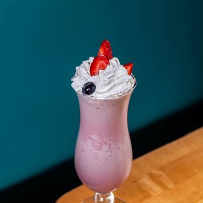 Strawberry milkshake topped with whipped cream.