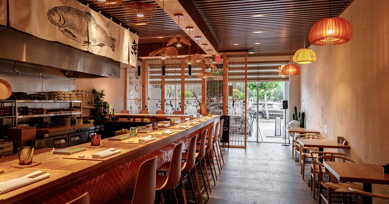 Interior, tables and chairs lined up on the right, bar and bar stools on the left