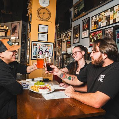 Seated patrons clink glasses in a toast at table.