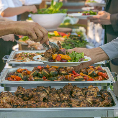 Employee pouring chili pepper salad for one guest