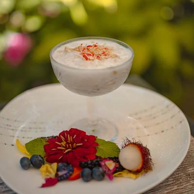 Warm Coconut Rice Pudding garnished with flowers and berries.