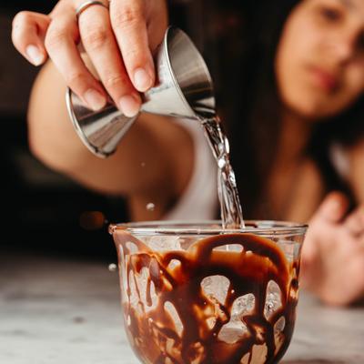 A person pouring a shot into a glass.