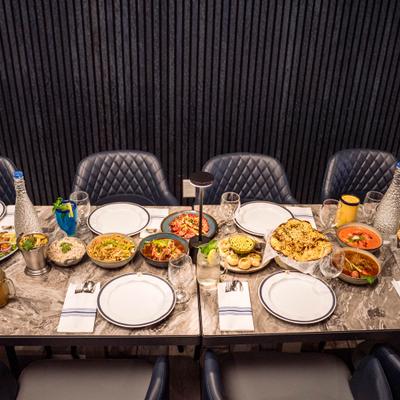 A dining table set with assorted dishes, beverages, and place settings.