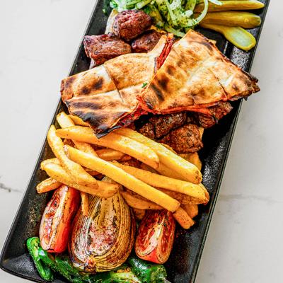 Platter with shish kabab, chili bread, fries, pickles.