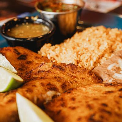 Fried fish fillets with rice, beans, and salsa.