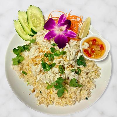 Thai crab fried rice garnished with fresh cucumber, lime, and chilies.