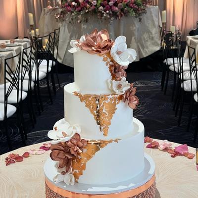 A beautifully decorated multi-tiered wedding cake, the centerpiece of a wedding reception.