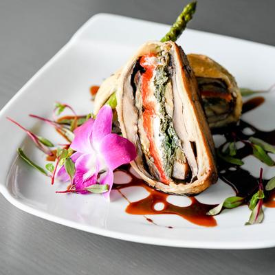 Portobello mushroom sandwich on a plate with orchid garnish.