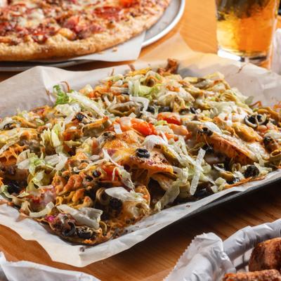 Deluxe Nachos topped with cheese, lettuce, tomatoes, black beans, and jalapeños.