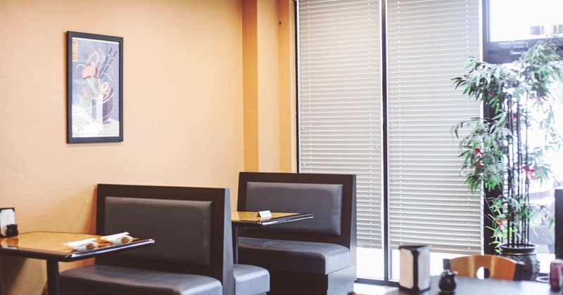 Dining booths, picture on a wall and bamboo plant in a pot