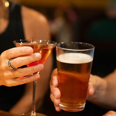 Hands toasting with drinks, closeup.