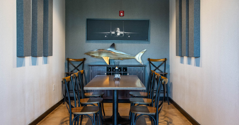 Interior, table with a big fish sculpture hanging on the wall