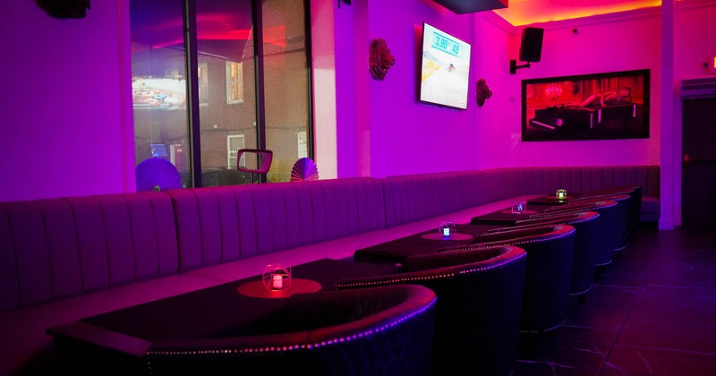 Interior, purple lighting, tables, sofas and long leather benches