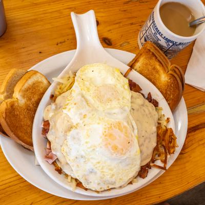 Haystack skillet topped with fried eggs and served with toast.