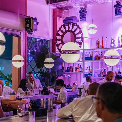 Guests seated around the bar beneath hanging lights.
