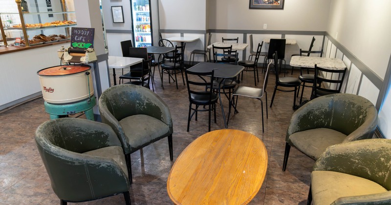 Interior, armchairs, an oval coffee table, a pastry counter, and beverage refrigerator