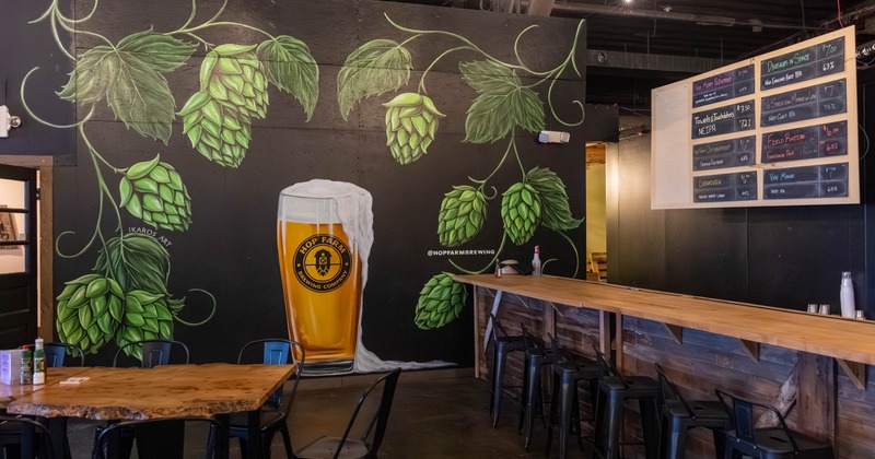 Taproom interior with a mural featuring hops and a glass of beer