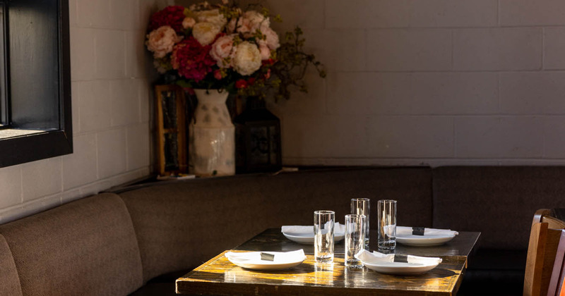 Interior, table set and ready for guests, flowers in a vase