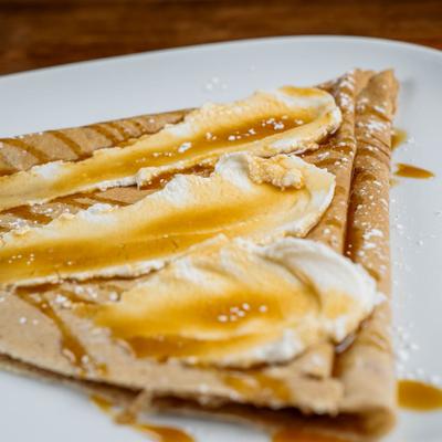 Crepe topped with ricotta, a drizzle of caramel sauce and dusting of powdered sugar.