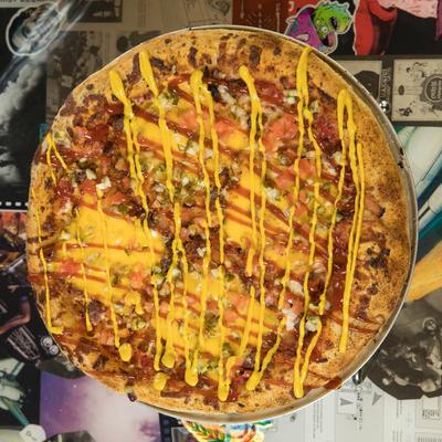 Cheeseburger Pizza with beef, bacon, onions, pickles, tomatoes, ketchup and mustard.