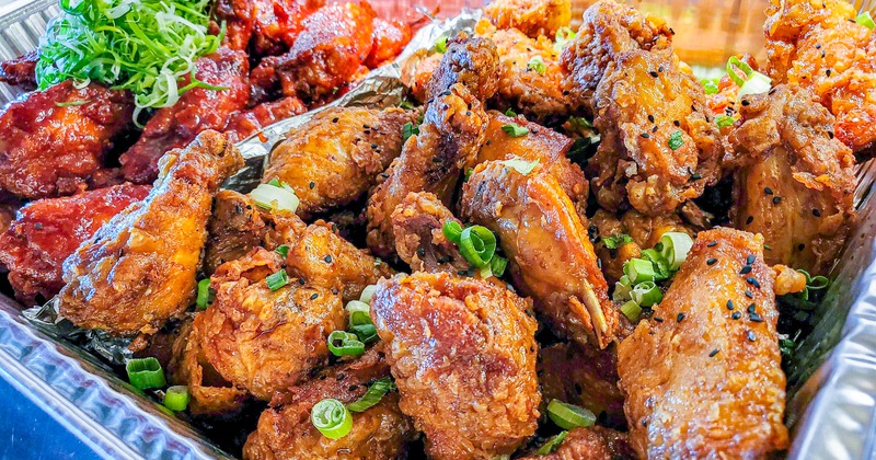 A pan full of different flavored chicken wings