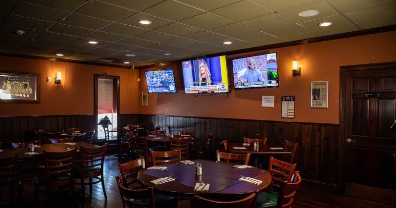 Interior, set tables ready for guests, TVs on the wall