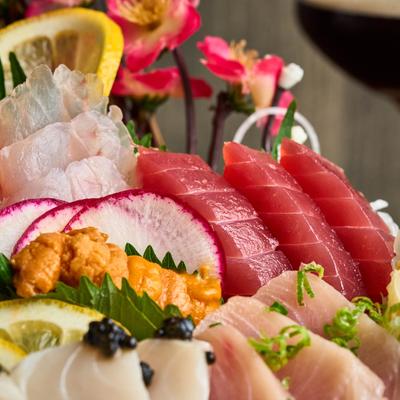 A colorful sashimi platter featuring fresh tuna, salmon, and white fish.