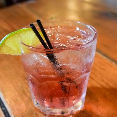 Vodka and cranberry drink served in rocks glass with a slice of lime.