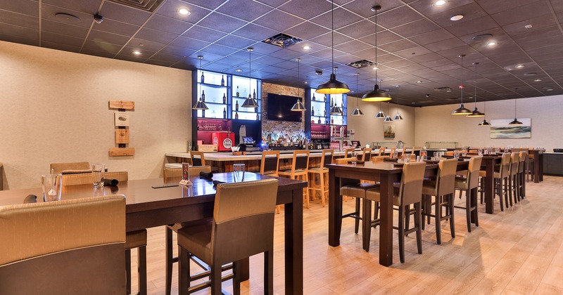 Modern style of dining area design with high tables set for guests and a bar area