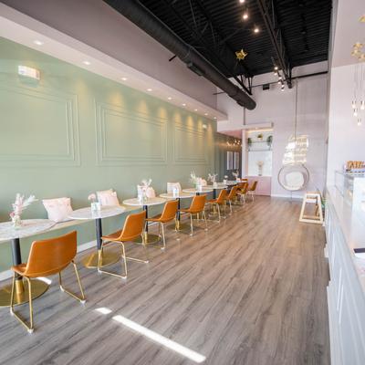 Interior, long banquette bench built in the wall, round marble top tables with chairs.