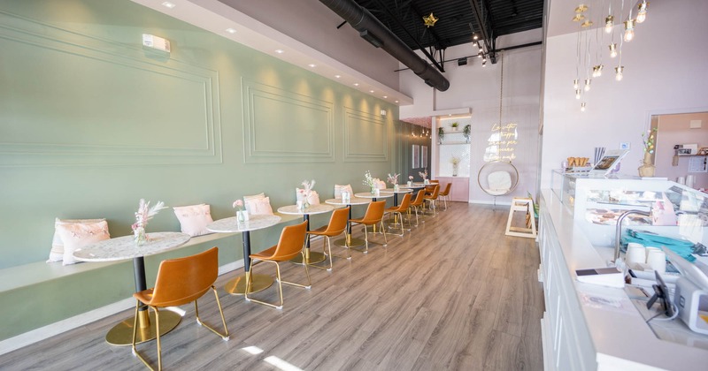 Interior, long banquette bench built in the wall, round marble top tables with chairs