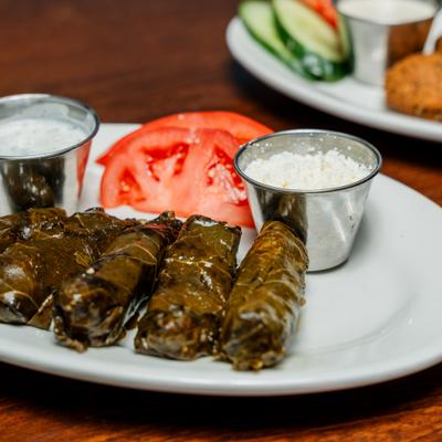 Stuffed grape leaves served with feta and a side of tzatziki.
