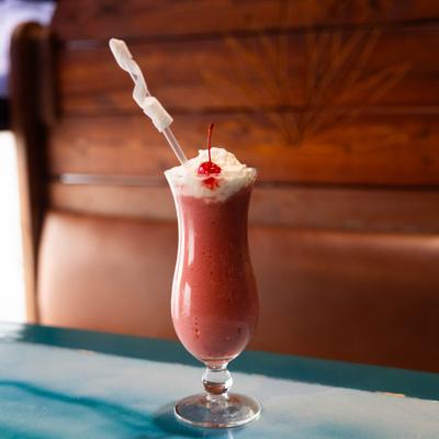 Strawberry Daquiri topped with whipped cream and garnished with a cherry