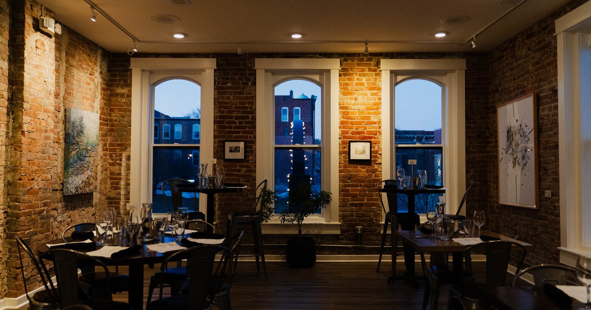 Interior, dining area, tables with chairs, vintage red brick walls, windows