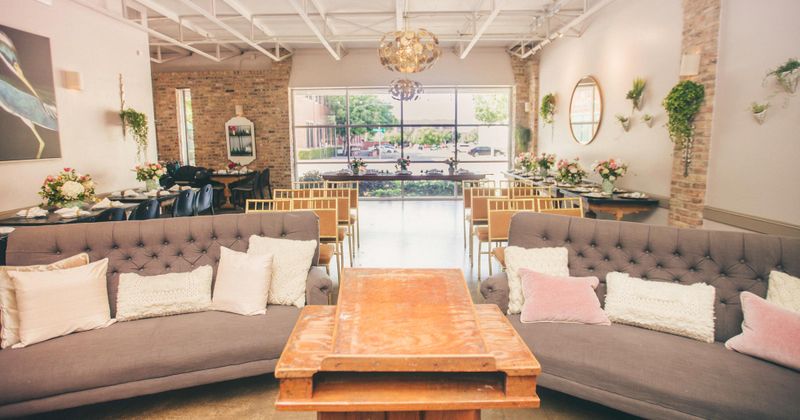 Interior, upholstered button tufted sofas with pillows and a table, set tables in the back