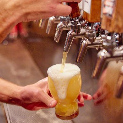 Beer being poured from tap wall.
