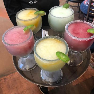 Frozen margaritas on a tray held by a waitperson.